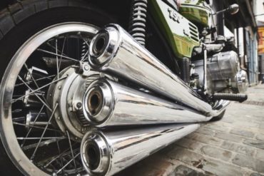 Close-up of three motorcycle exhaust pipes on a Benelli Sei 750