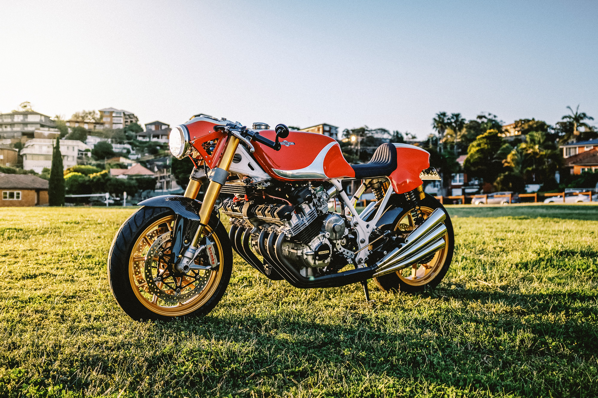 A Honda CBX cafe racer on a grass field at sunset in Sydney